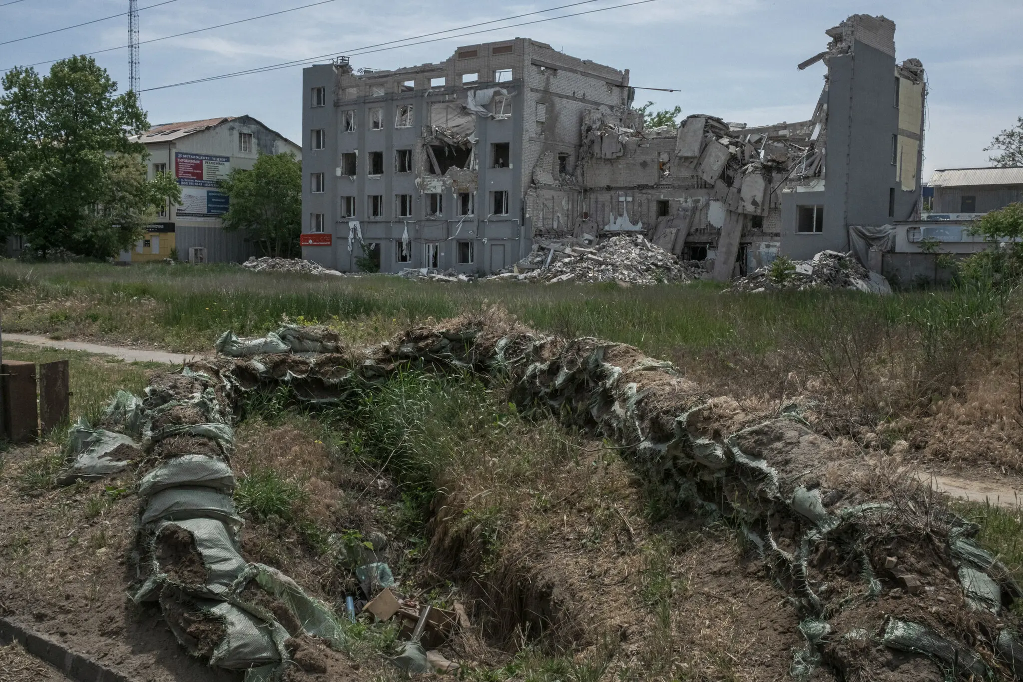 Занедбана траншея біля зруйнованої будівлі в Херсоні. Україна відновила контроль над містом у 2022 році, але російські війська продовжують утримувати позиції на протилежному березі Дніпра.